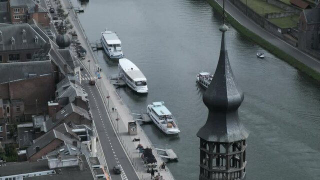 Aerial View of Three Boats Docked in the River Meuse in Dinant, Belgium. Another Boat Passes By