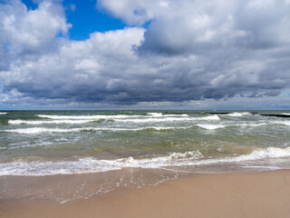 Fototapeta na wymiar strong swell at the Baltic Sea and the sky is blue and cloudy