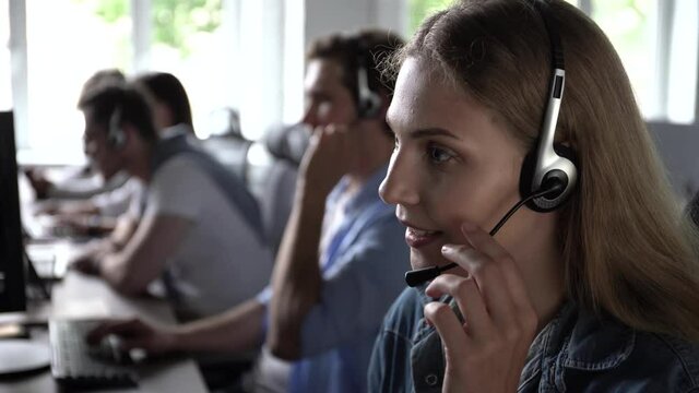 Service phone operators sit at shared desk focus on sales. Agent woman in headset use pc answers incoming calls talk with client provide professional support to customers sell company product concept