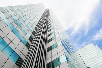 Modern business office building with glass windows reflect the skyline that view from below in Bangkok, Thailand.