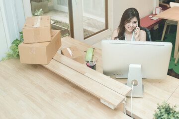 Young entrepreneur working on the smart computer while talking to her customer at home office.Conceptual for small businesses starting own company and online marketing.