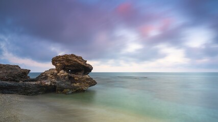 Scenic shot of a seashore with unique rock formations and colorful sky