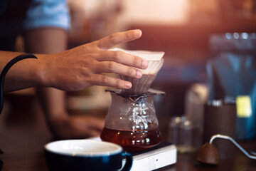 Obraz na płótnie Canvas Barista measuring coffee drip with glass mug