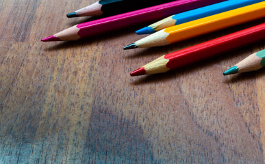 Obraz premium Colored pencils close up on wooden background