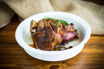 baked pork shank with spices in ceramic form