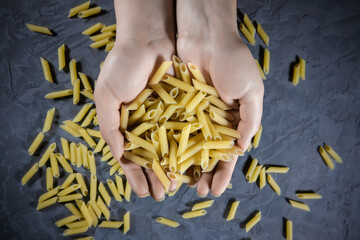 Pasta scattered in the palm on a dark background