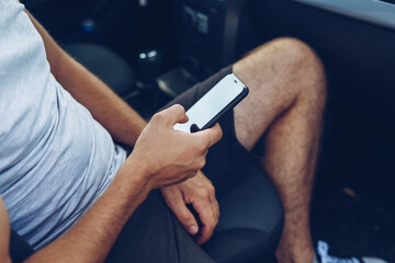 Photo of man hands touching phone in car. Lifestyle, travel, technology concept.