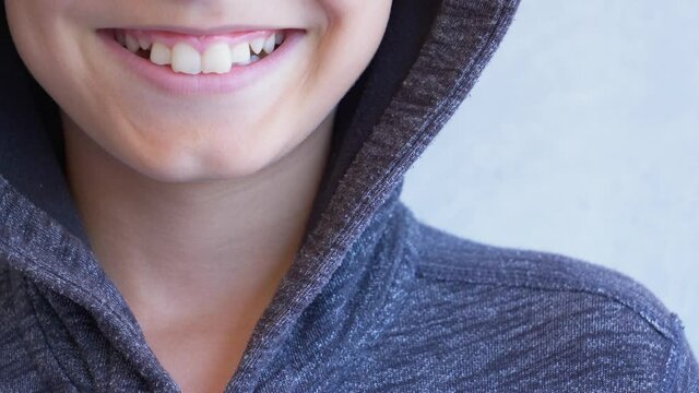 Close up mouth of cute boy smiling and showing white teeth. Cheerful kid laughing into camera with joyful smile. Happy child face. Front view