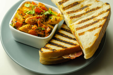 White bread with beechwood smoked bacon, egg, mayonnaise, and tomato served with Caesar pasta with parmesan cheese