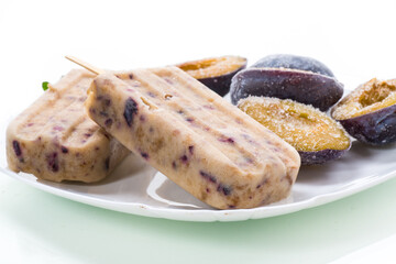 plum sweet homemade ice cream on a stick with slices of plum inside, in a plate