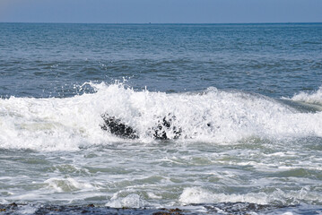 Sea breeze breaking on the rocks
