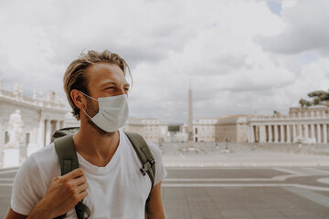 Man steht auf Petersplatz in Rom mit Atemmaske