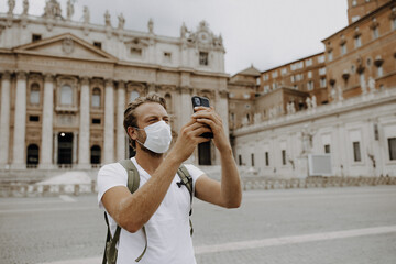 Mann als Tourist  mit Maske und Mundschutz auf Petersplatz in Rom