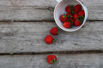 strawberries in a cup on a wooden old background