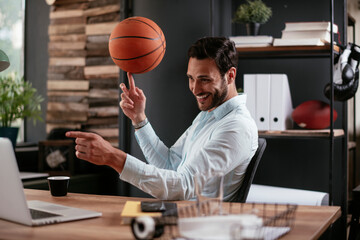 Businessman having a video call on laptop. Handsome businessman having fun while working in office.