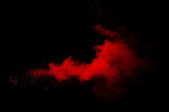 Abstract red powder on black background. Red color clouds.
