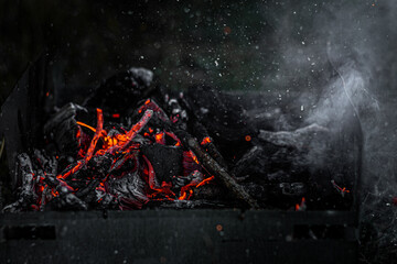 Burning coals in the grill, flame and smoke.