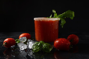 Glass of fresh tomato juice and tomatoes on Dark background with water drops