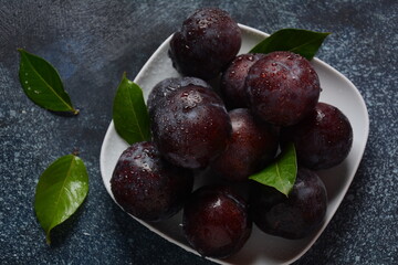 Juicy plums in a plate. Fresh Blue plums. 
