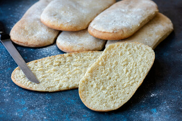 
homemade whole and cut focaccia bread on blue background