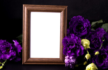 Empty mourning photo frame next to purple flowers. Sorrow concept