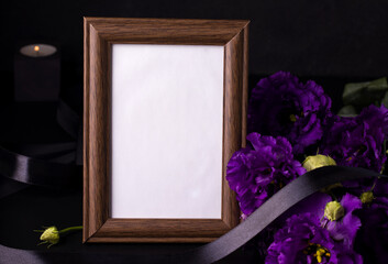 Funeral wooden frame next to flowers. Sorrow and obituary concept.