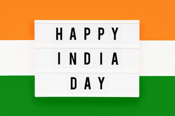 HAPPY INDIA DAY written in a lightbox on a background of Indian flag color. Independence day date. Top view