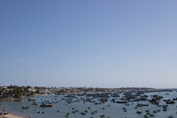 Fototapeta na wymiar MUI NE / VIETNAM - December 28, 2019 : view on Fishing village and traditional fishing boat with hundreds boats anchored ( fishing harbour market)