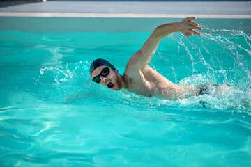 Male excellent swimmer moving in pool water
