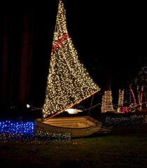 Holiday image is a sailboat with Christmas lights at night for a holiday display.