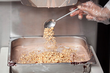 Making Of Ice Cream - Pouring nuts in the tray with ice cream