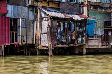 Fototapeta na wymiar Housing along the Mekong River, hanging over the water in Southern Vietnam.