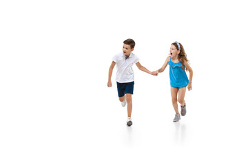 Happy kids, little and emotional caucasian boy and girl jumping and running isolated on white background. Look happy, cheerful, sincere. Copyspace for ad. Childhood, education, happiness concept.