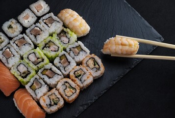High angle view of a sushi platter with chopsticks on the table under the lights - Powered by Adobe