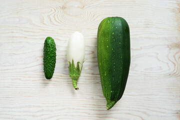 Green vegetables, cabbage, cucumber, dill and white eggplant on a light background.