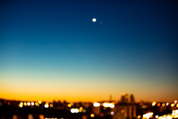 Blurred out of focus photo of city in dawn with star on the sky.