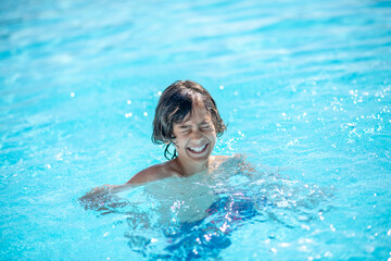 Boy in water smiling with closed eyes