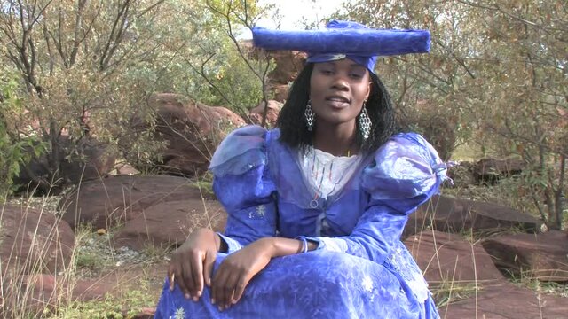 herero woman wearing a Victorian style dress outdoors in a village in north Botswana
