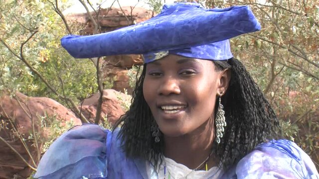 herero woman wearing a Victorian style dress outdoors in a village in north Botswana