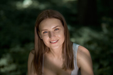 Portrait of a young beautiful smiling girl who looks at the camera.