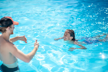Male instructor and boy learning to swim.