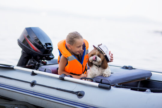 Little Girl In A Life Jacket With Her Dog In A Boat On The Lake. Safety. Summer Rest.