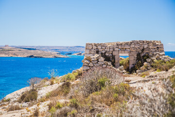 "Id - Dura"; traditional stone house built by farmers and hunters overlooking the the islands of Comino and Malta behind. Photo captured from Hondoq Ir Rummien, Gozo
