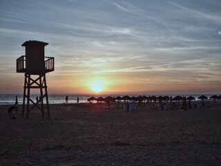 Silhouette of a lifeguard tower at sunset