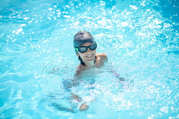 Fototapeta na wymiar Boy in swimming cap in water up to neck