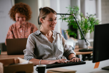 Happy businesswoman working on laptop. Young businesswoman working in the office.