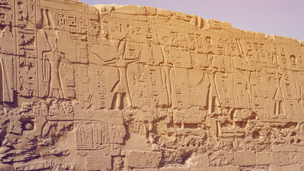 Fototapeta na wymiar Luxor Egypt karnak temple behind big wall craved with hieroglyphics of god and pharaoh large size
