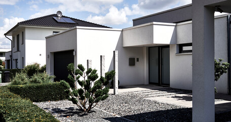 Entrance area of a modern city villa in minimalist design, with a gravel garden, view from public ground