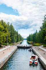 Fototapeta premium Asikkala, Finland - 16 July 2020: Vaaksy Canal between two big lakes Vesijarvi and Paijanne. Gateway is open for boats going though.