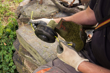 changing strings in a string trimmer, close-up view of a man's hands